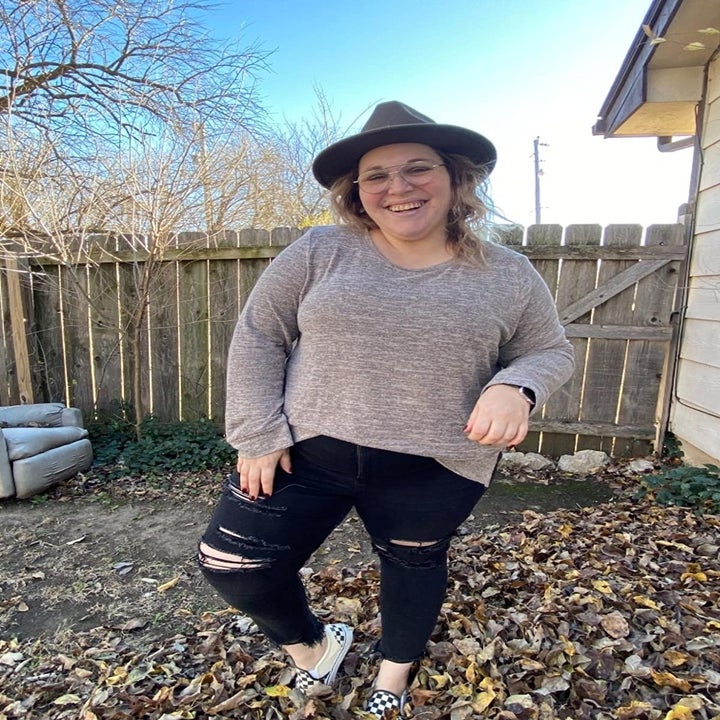 A reviewer in the grey top half-tucked into jeans