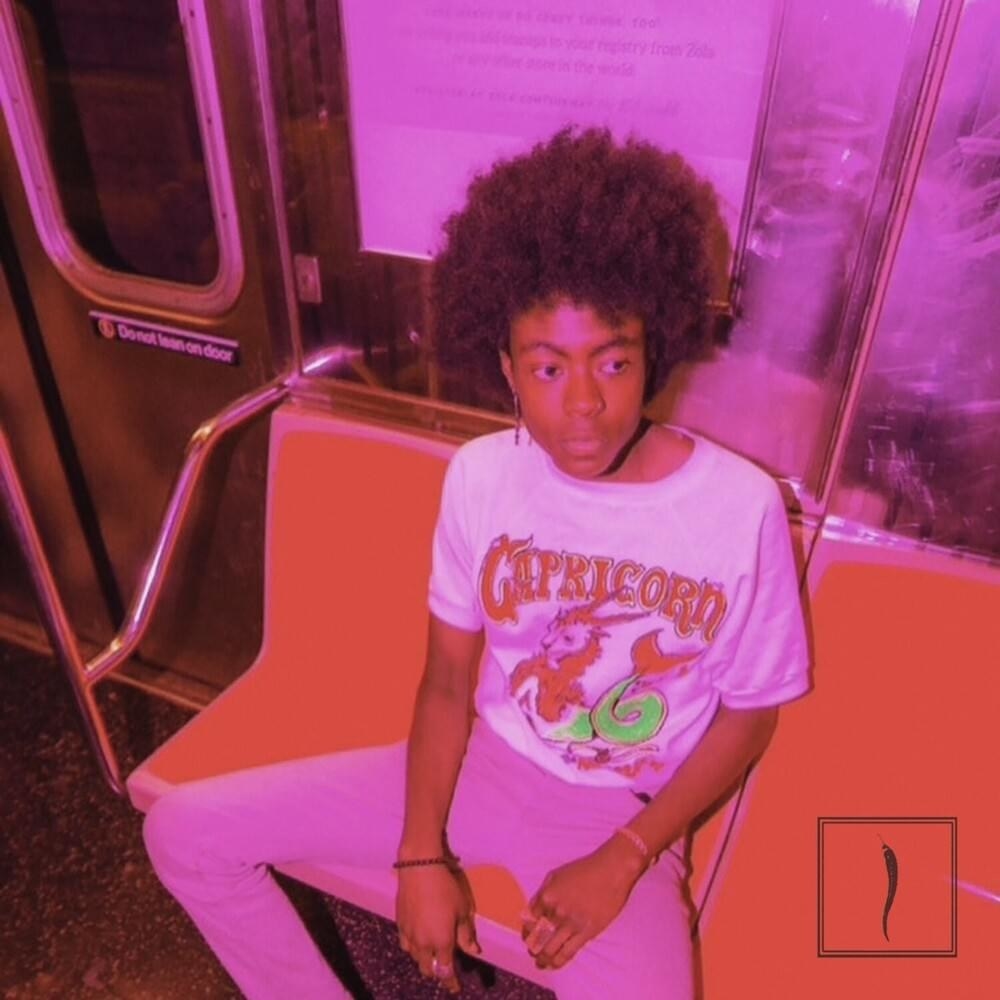 a young adult male with an afro sits on a subway seat, looking into the distance