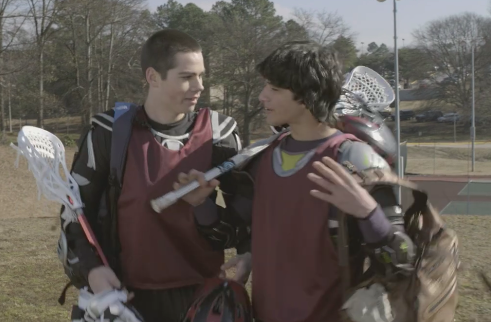 Scott and Stiles walking on field with lacrosse gear