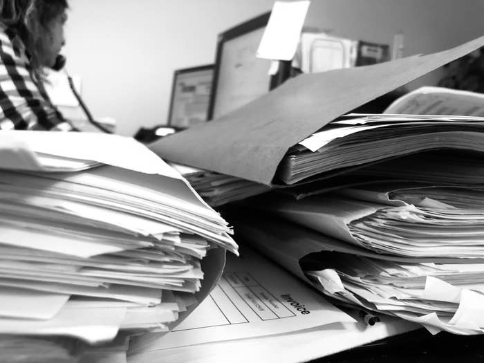 An unorganized desk filled with papers and folders