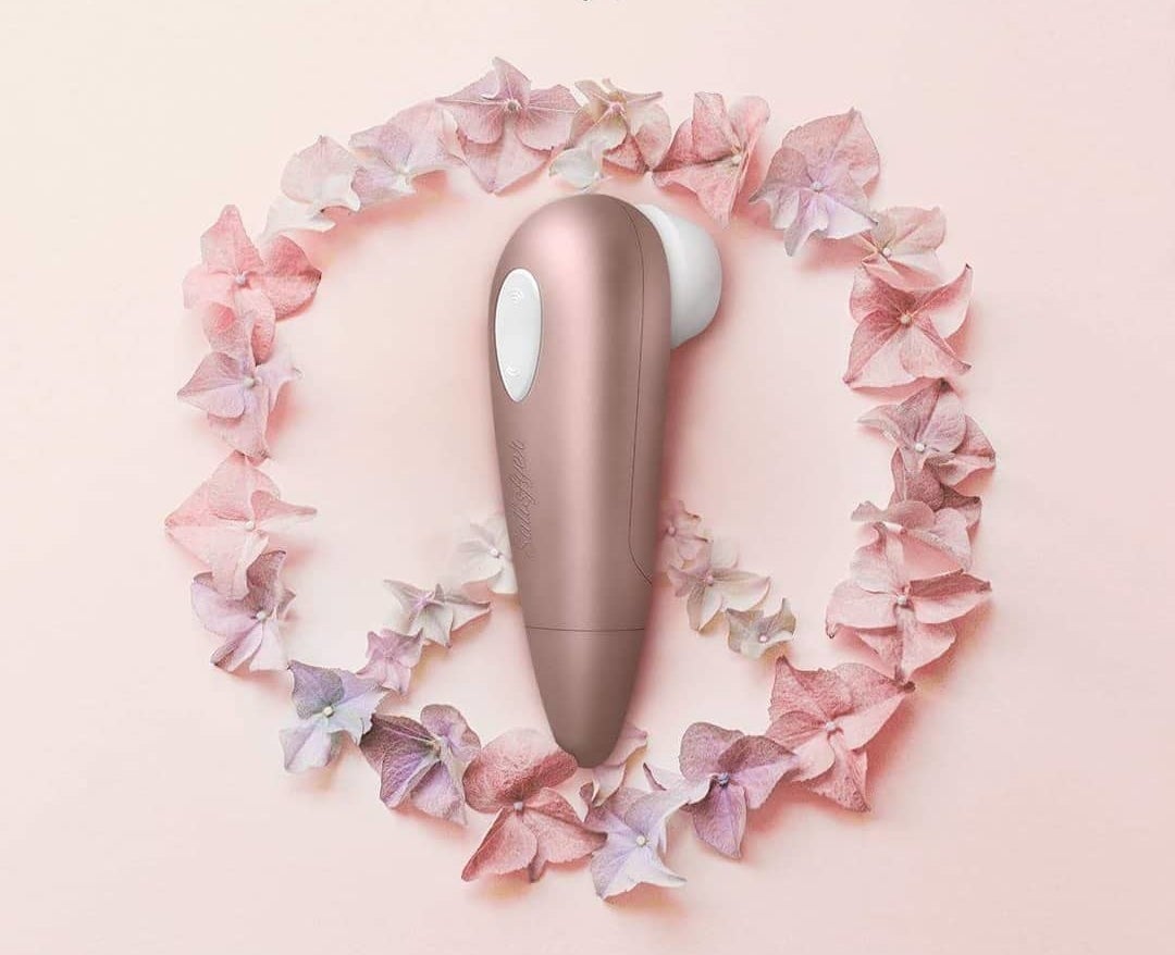 the satisfyer 1 on top of flowers in the shape of a peace sign