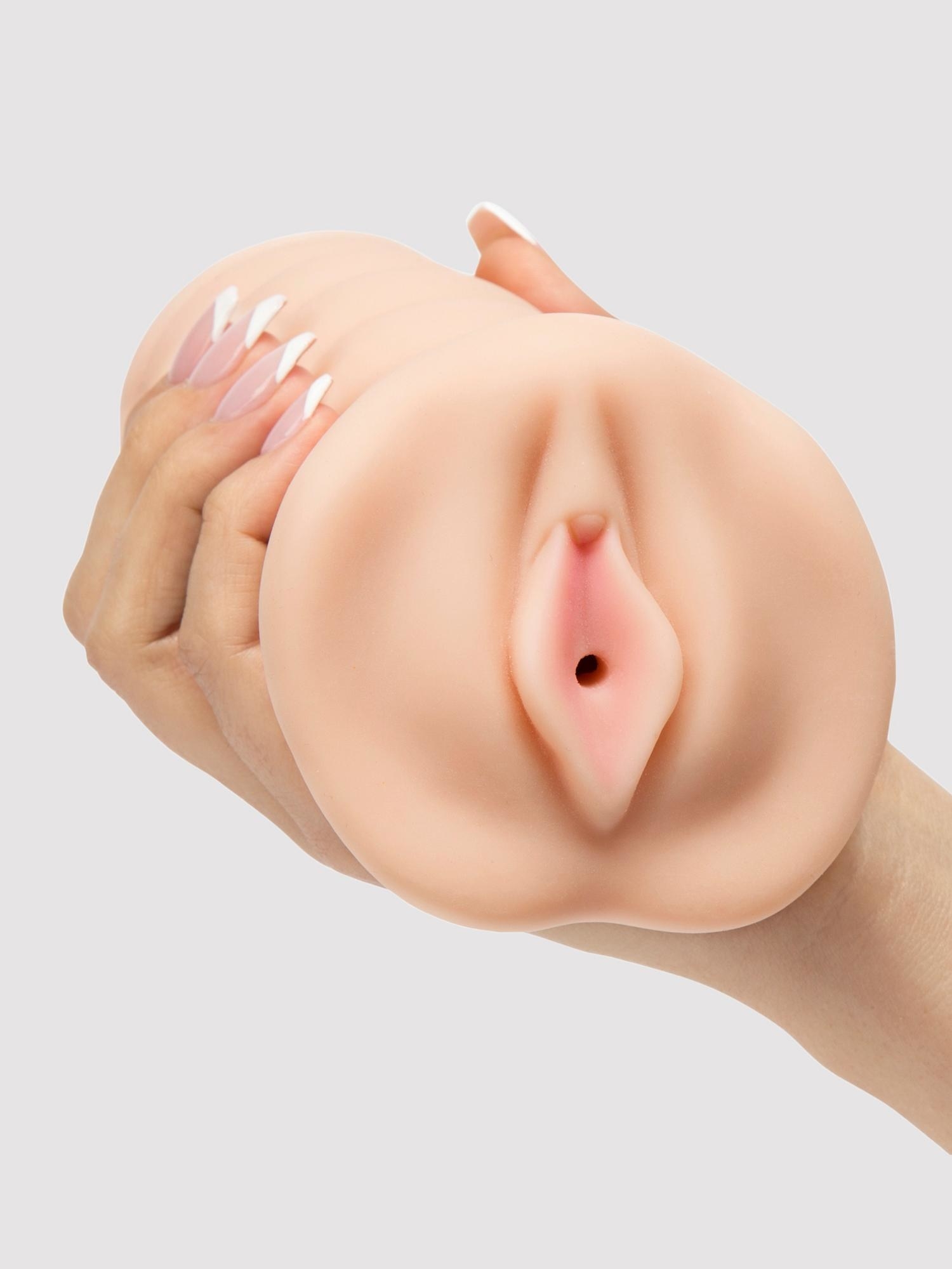 a model&#x27;s hand holds the THRUST Pro Ultra Holly Realistic Vagina