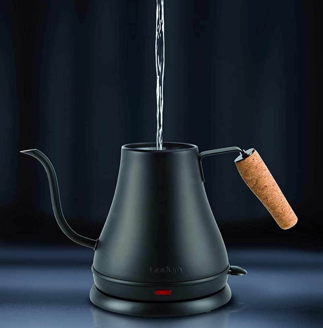 A person pouring water into the kettle