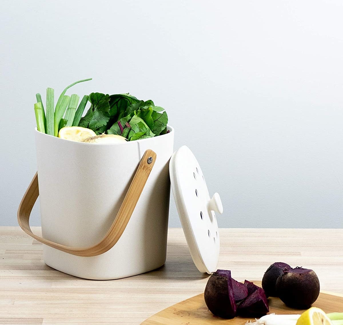 The white biodegradable composter which has a bamboo handle and vented lid