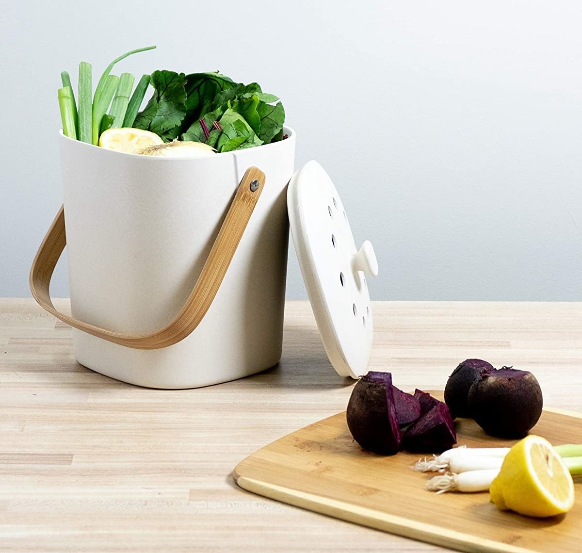 The white biodegradable composter which has a bamboo handle and vented lid