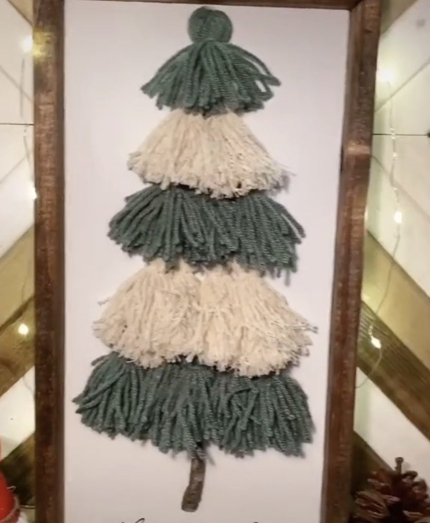 A green and white tree made from yarn in a frame