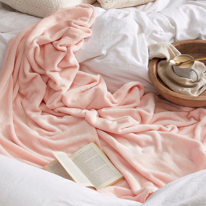 A fuzzy blanket in a pile on a bed