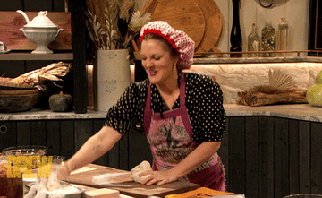 Drew Barrymore aggressively slaps a handful of powder onto a lump of dough on The Drew Barrymore Show