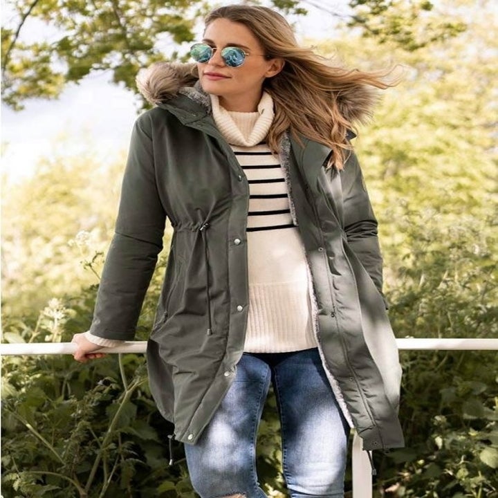 a pregnant model wearing an olive green parka