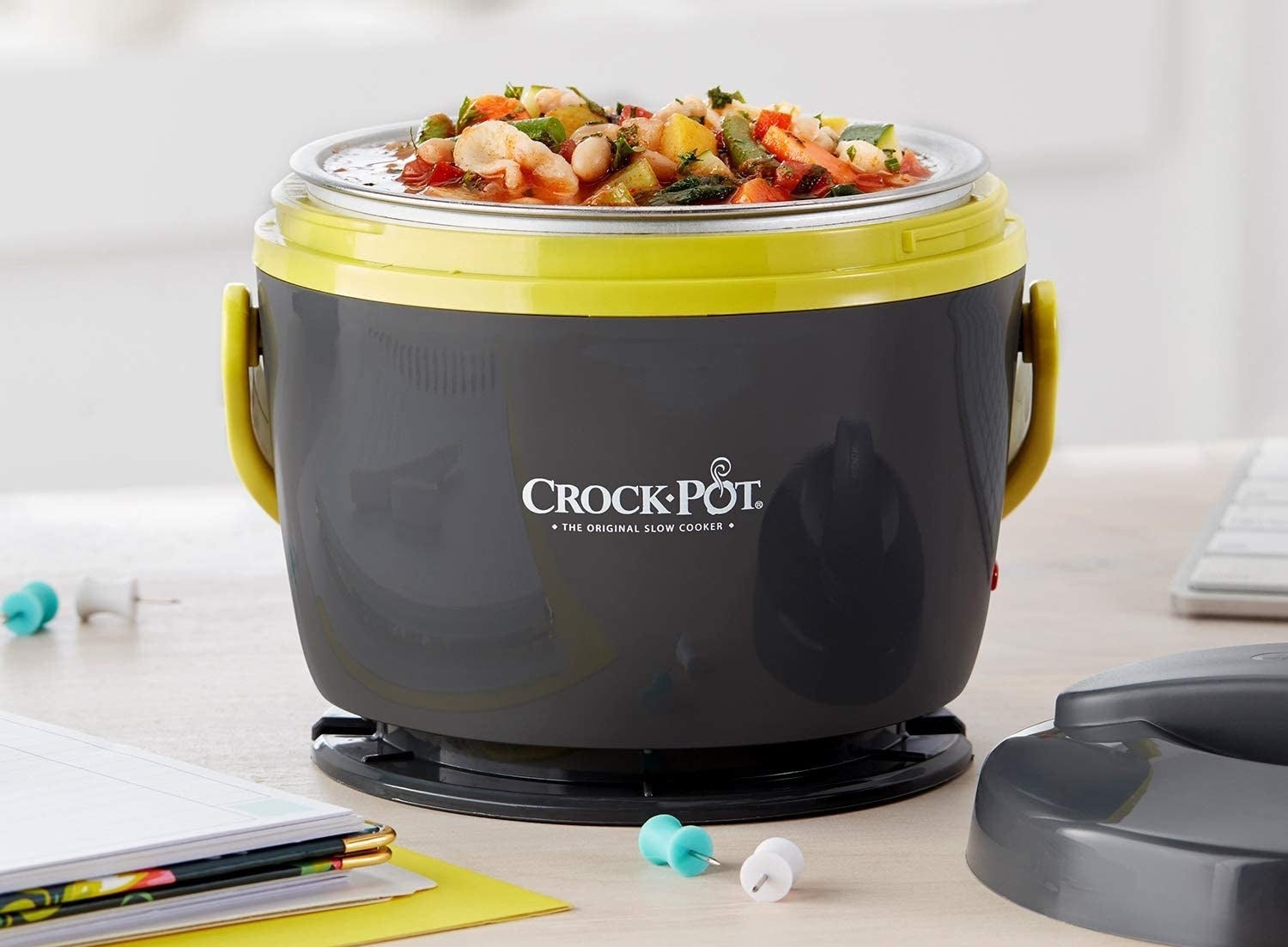 the crock pot lunch warmer full of soup sitting on a desk