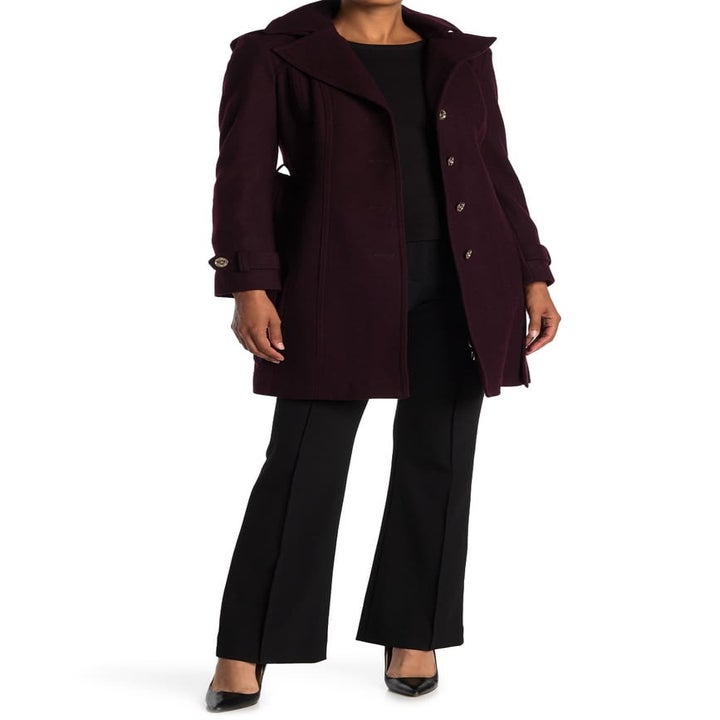 a model in a dark purple trench coat