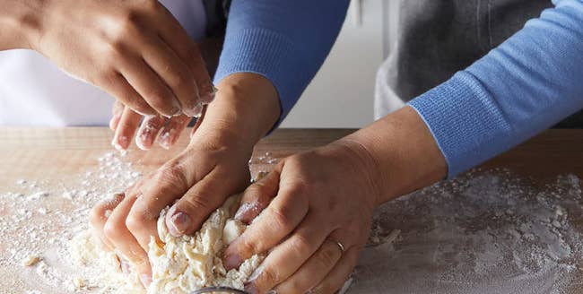 models' hands kneading dough