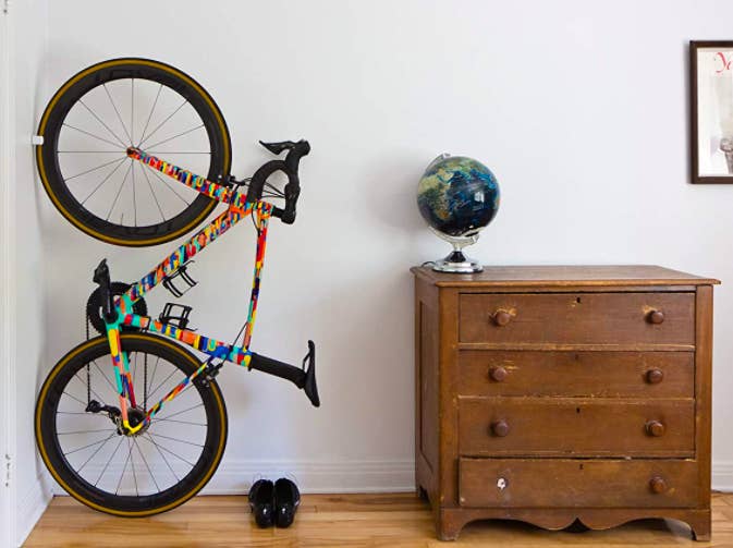 A bike stored vertically with a clip that attaches to the front wheel