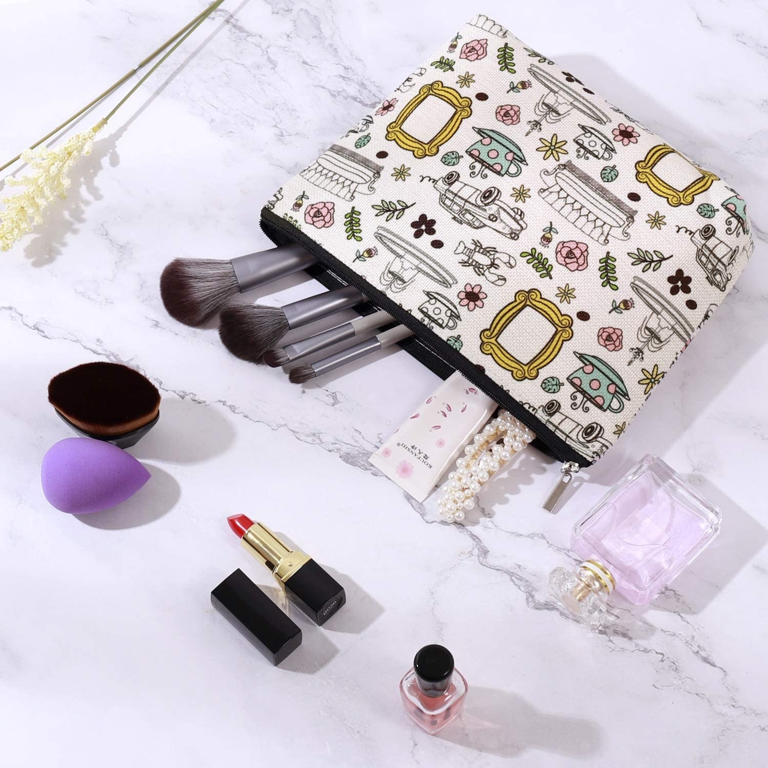 makeup bag with brushed, perfumes, nail polish, and beauty blender