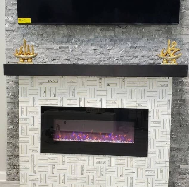 Reviewer&#x27;s picture of the electric fireplace attached to their wall