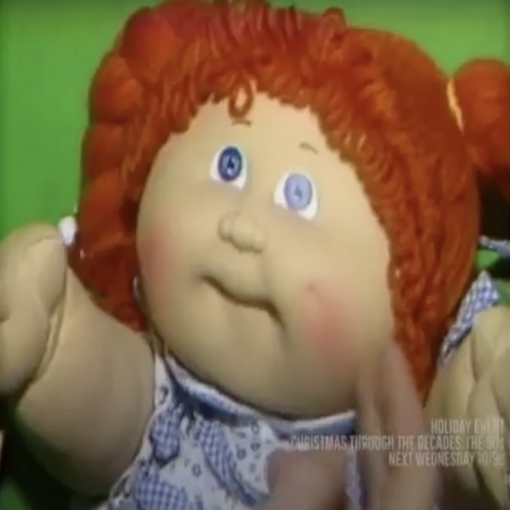 A close-up of a Cabbage Patch Kid with orange hair