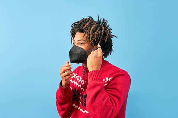 Young man in holiday sweater wearing a KN95 mask