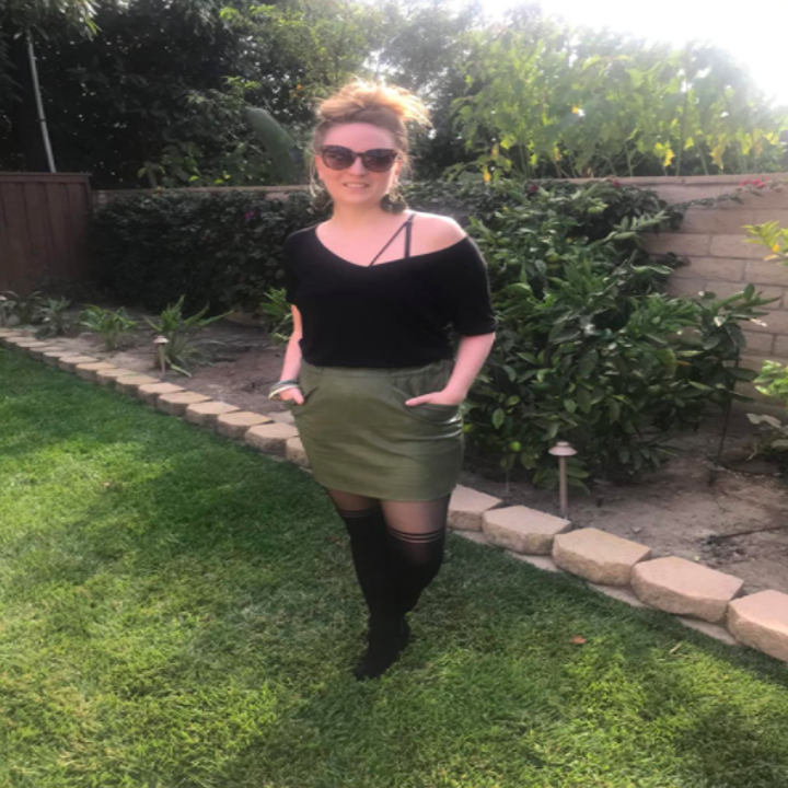 a reviewer wearing the shirt in black with a skirt