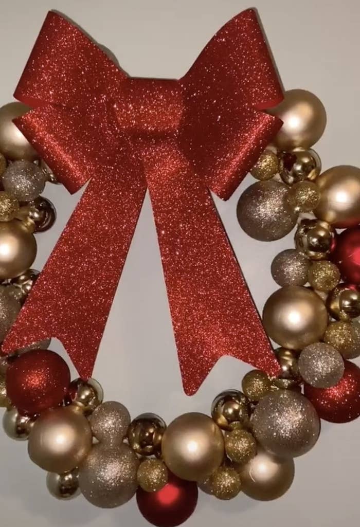 A wreath made of sparkling red and gold ornaments