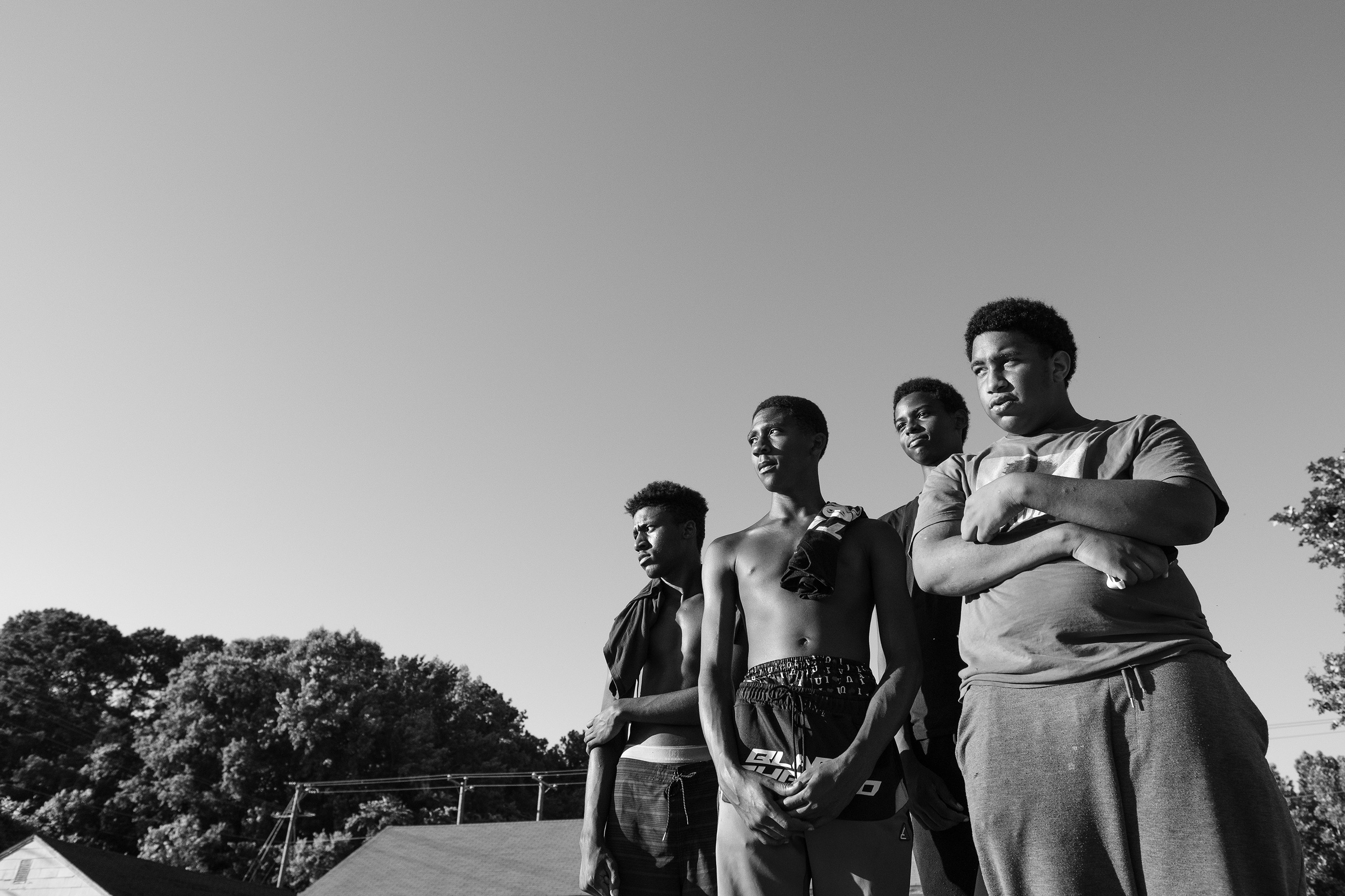 Four boys in the bottom right-hand corner of the frame looking off to the side