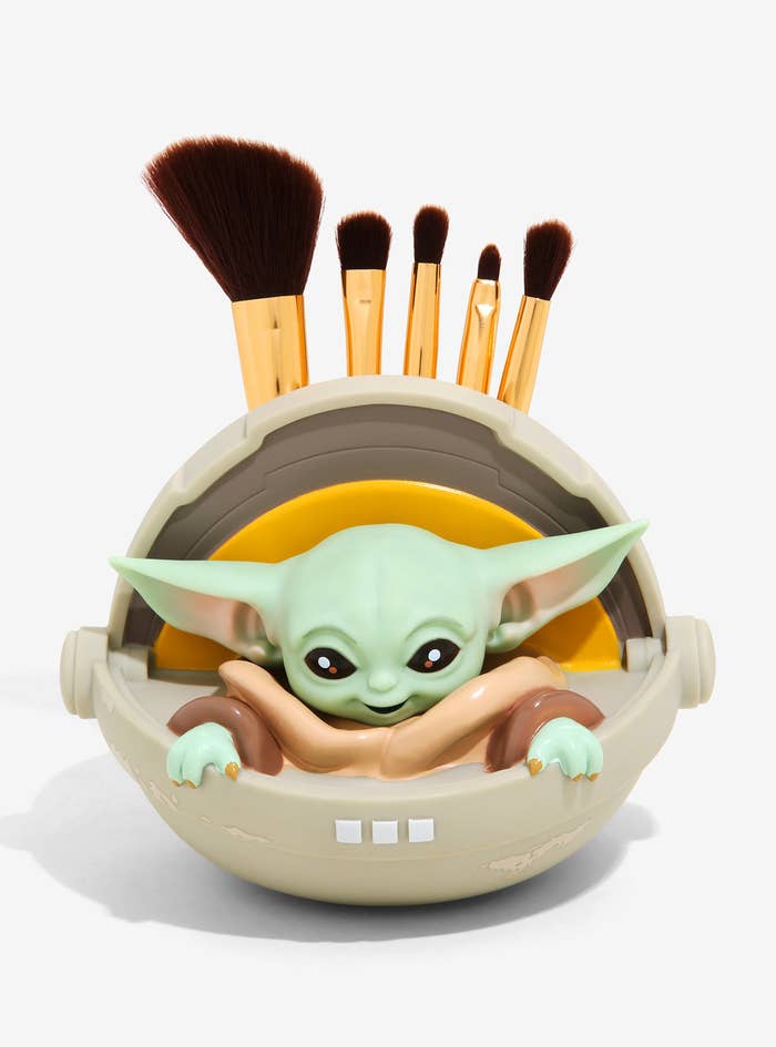 baby Yoda inside the crib pod which holds makeup brushes in the back