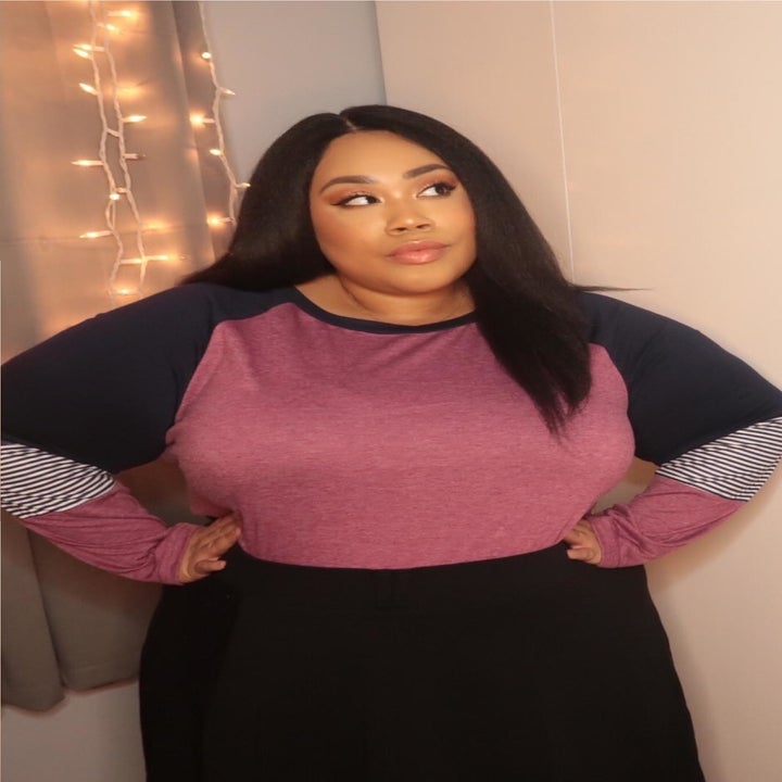 reviewer wearing top in pink with black shoulders and grey patch on the sleeves