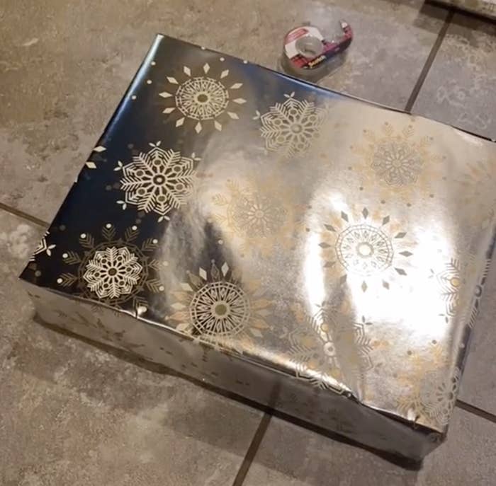 A well wrapped present near a role of tape