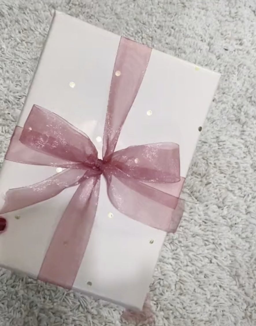 A white box with a pink bow