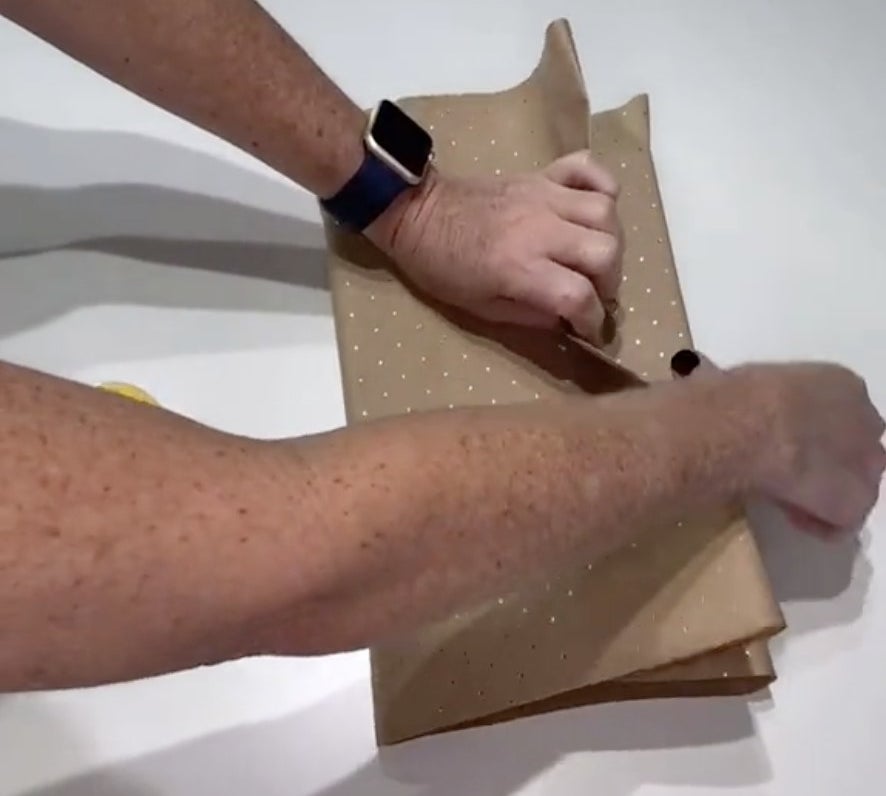 A man works on wrapping a present box