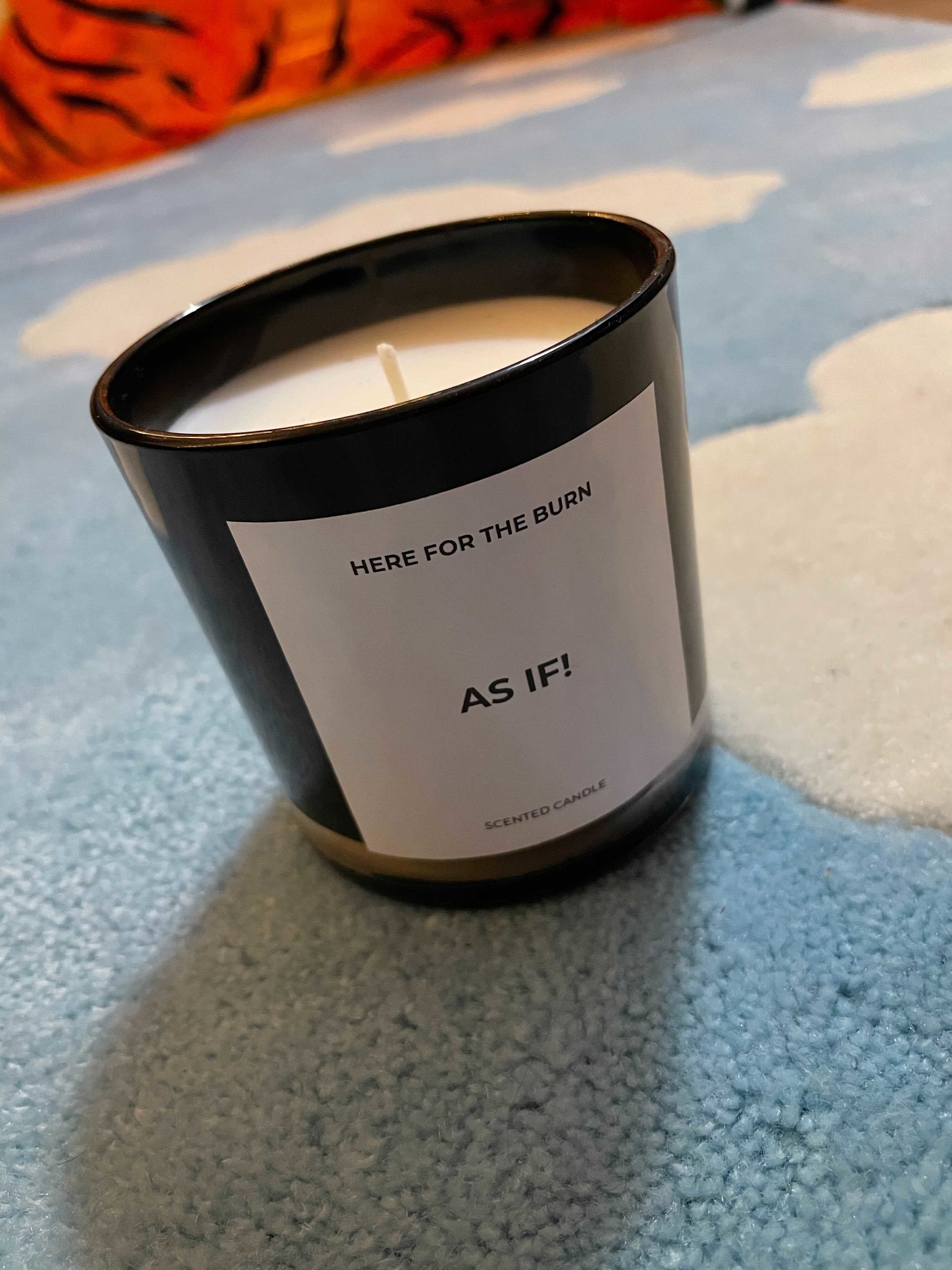 black candle with white wax that has a label that says as if!
