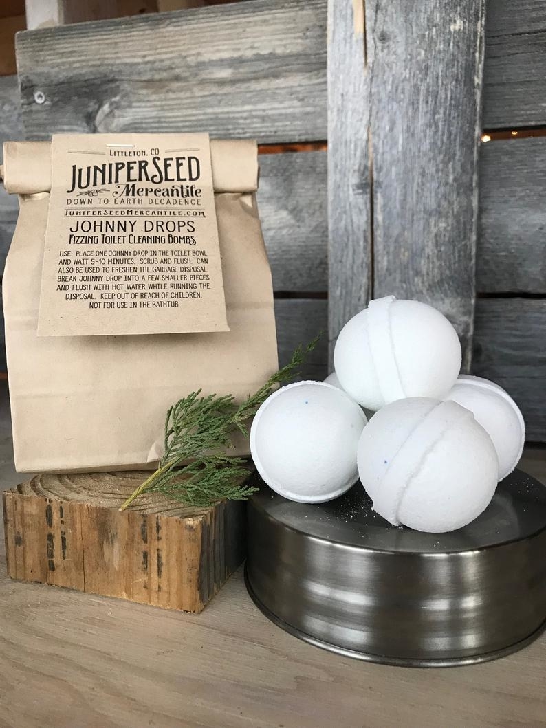 White bath bombs next to the brown paper bag packaging 