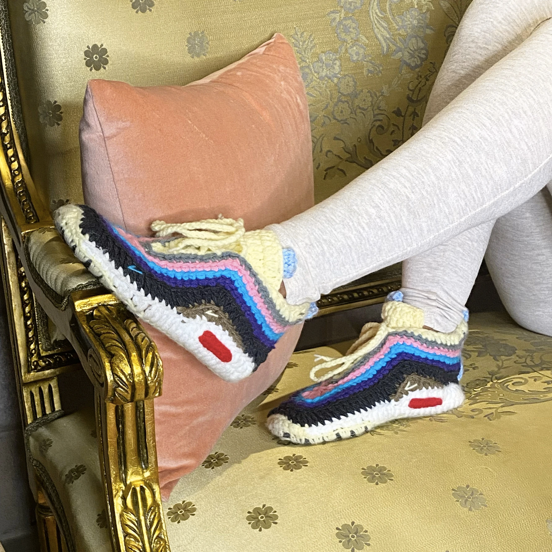 models wears knit slippers shaped like sneakers