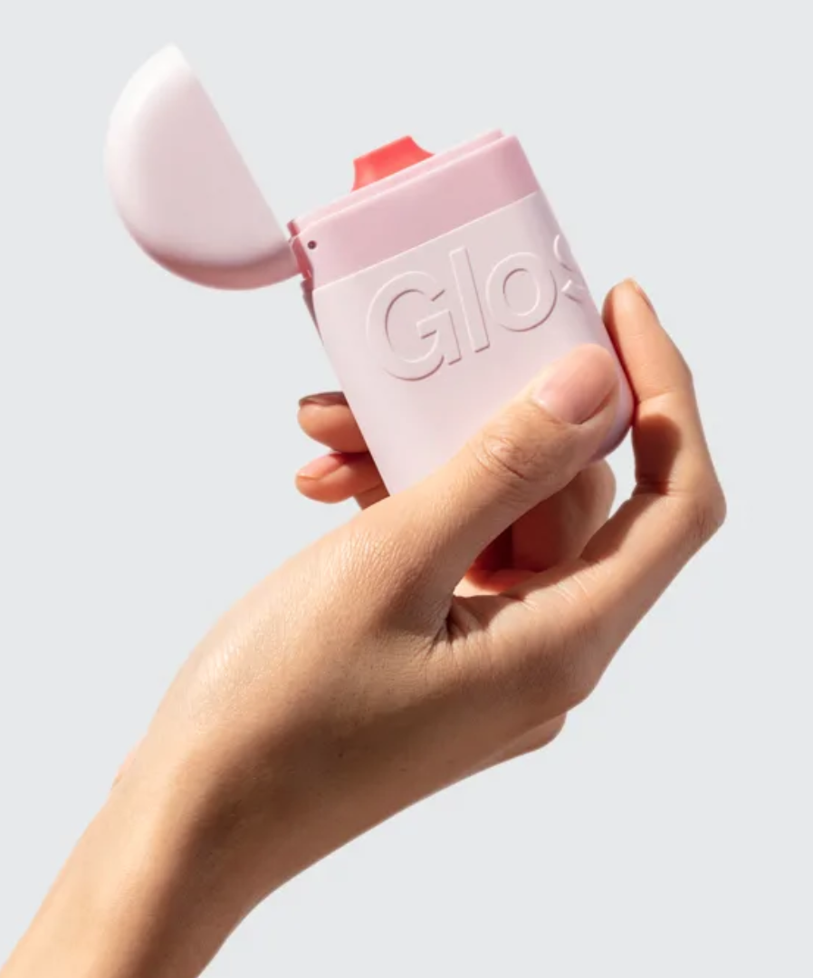 a model holding a pink rounded container with a flip top cap