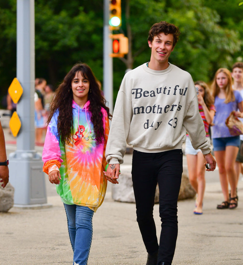 Shawn and Camila walking down a street