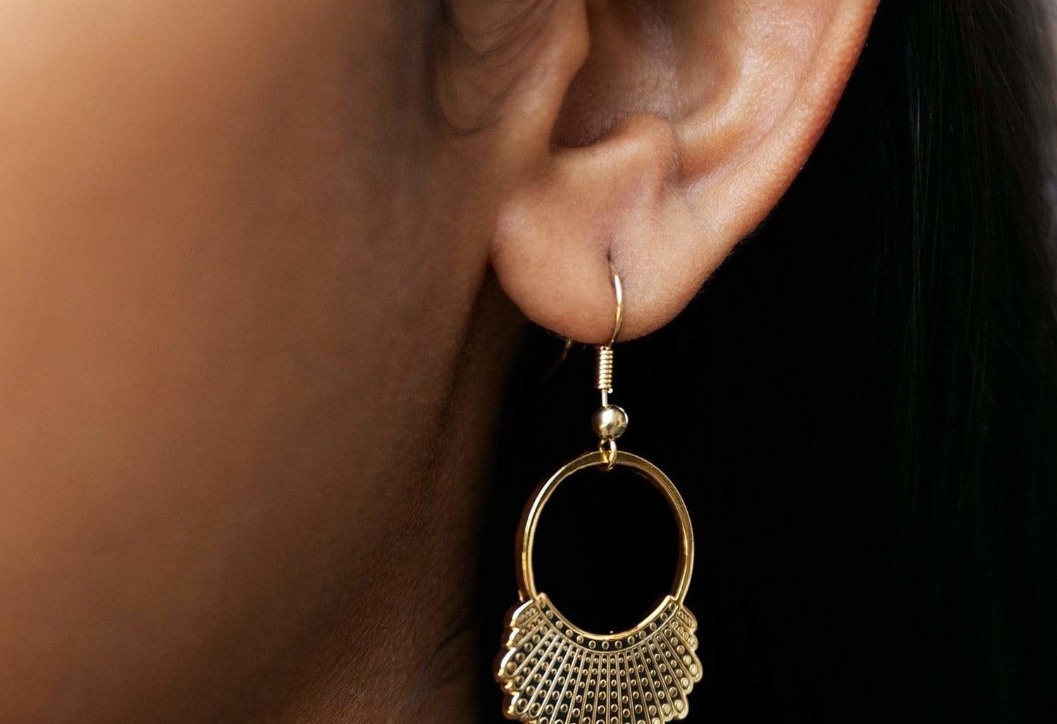 Model wearing gold plated hook and hoop earrings