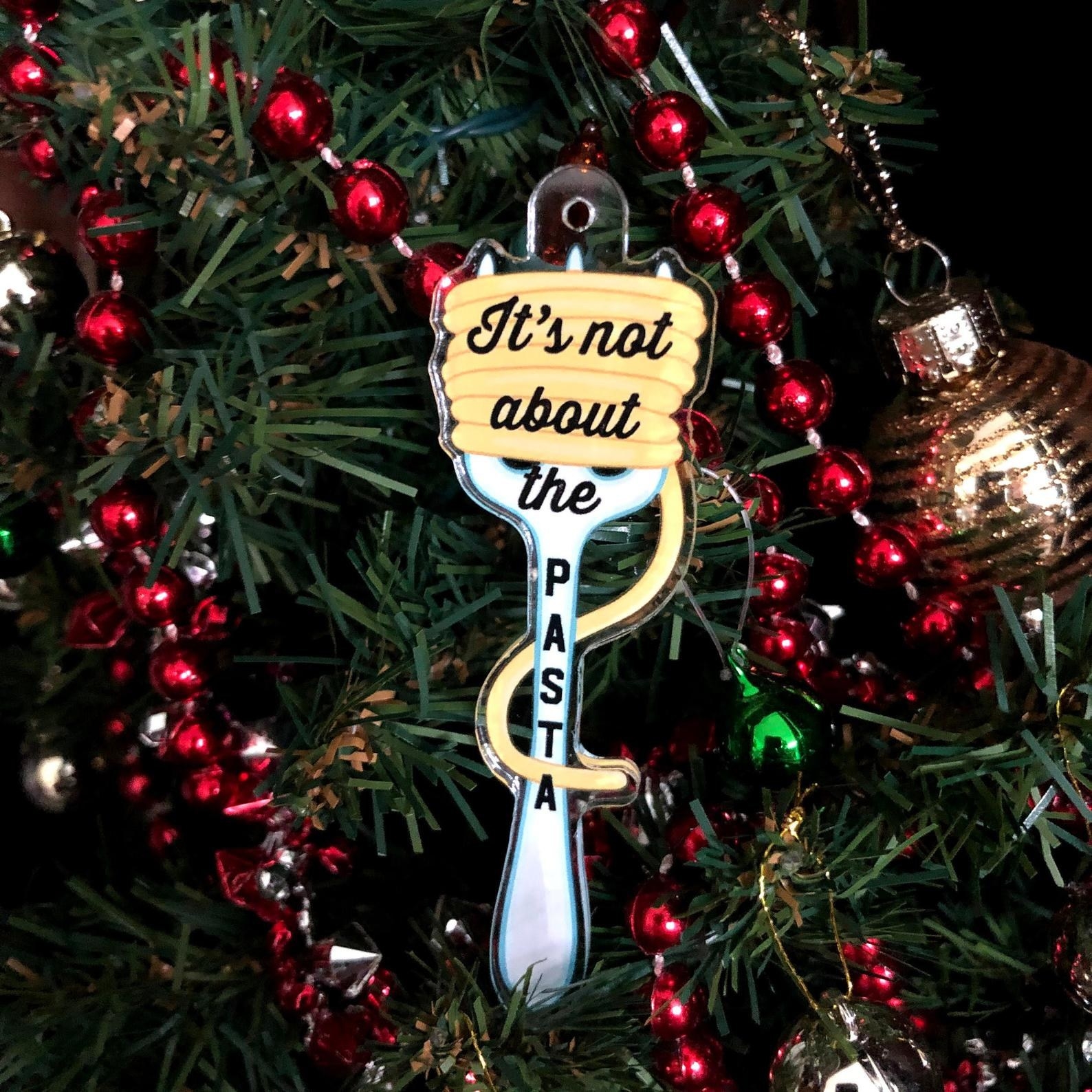 an ornament of a fork with spaghetti twirled around it and &quot;it&#x27;s not about the pasta&quot; written on it