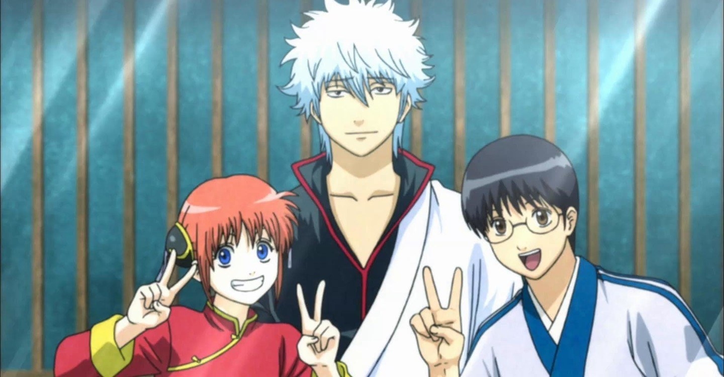 Gintoki Sakata standing together with two of his friends, who are smiling and posing with the peace sign