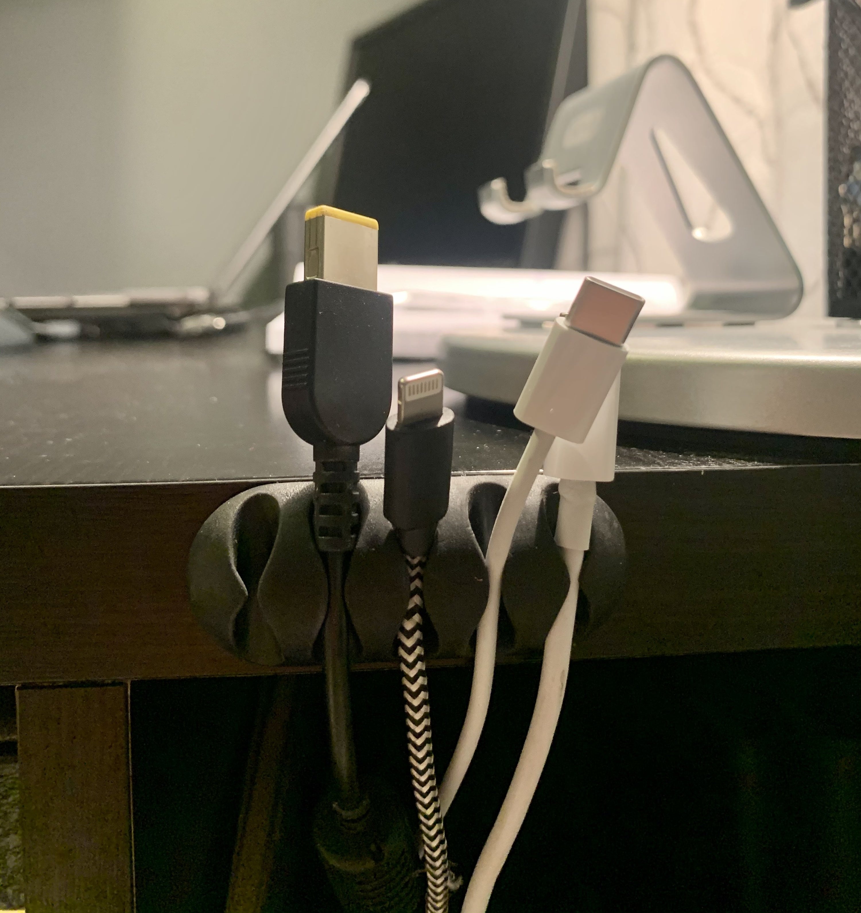 The cord clip is attached to May's desk and keeps her cords organized