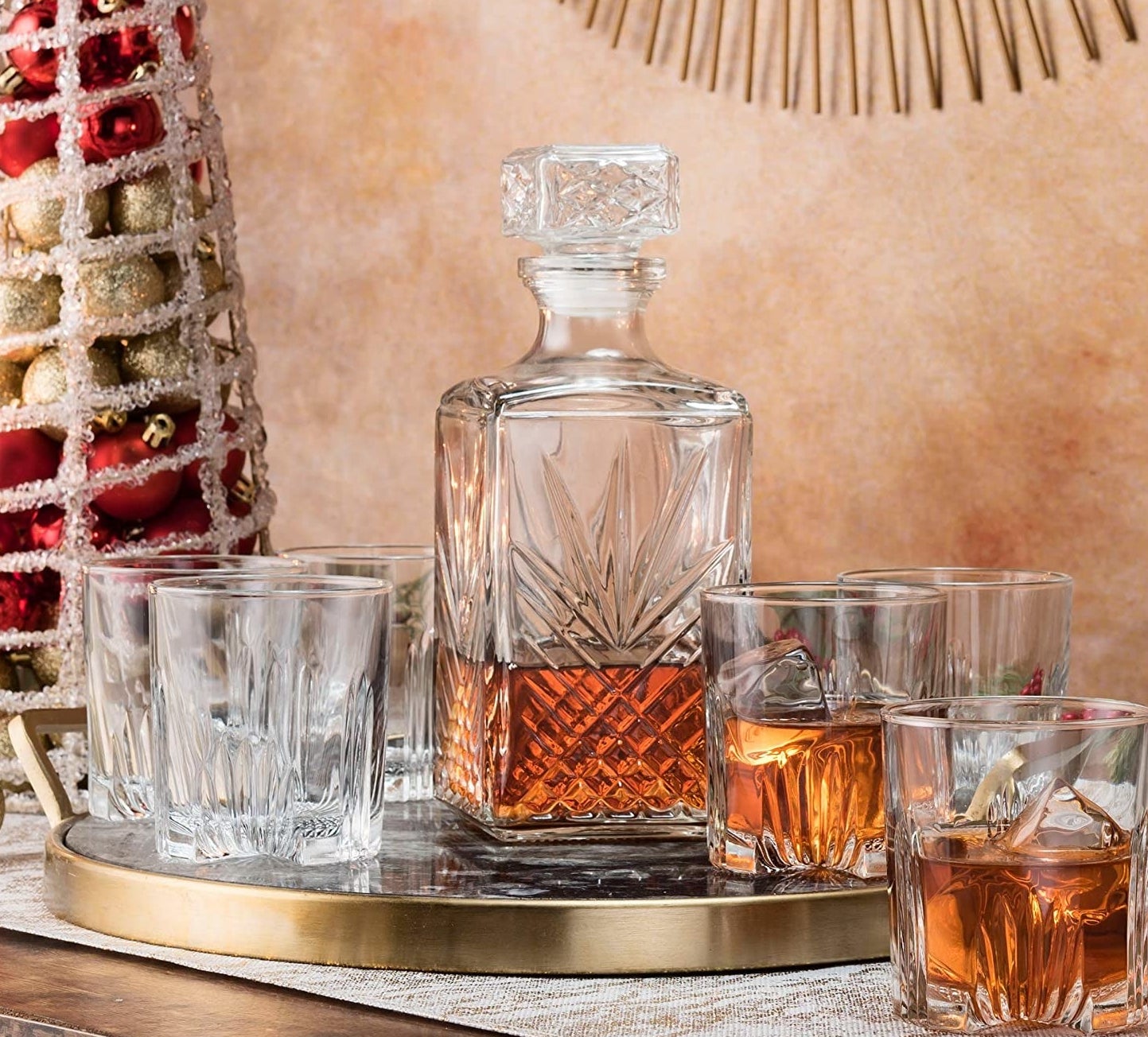 Six glasses beside a whisky decanter on a metallic tray