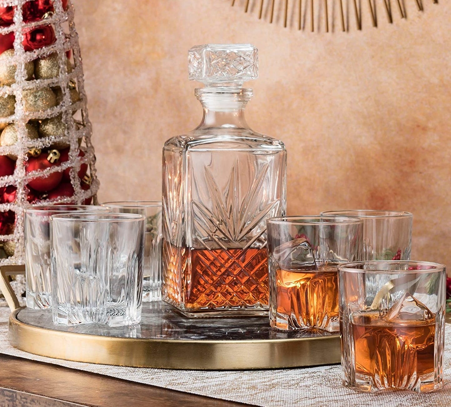 Six glasses beside a whisky decanter on a metallic tray