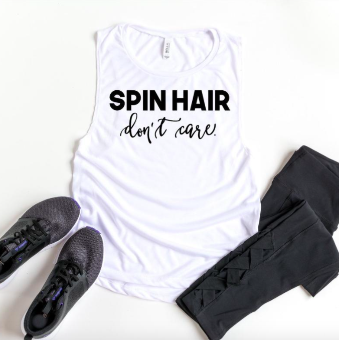A tank top that says Spin Hair don&#x27;t care next to sneakers and leggings
