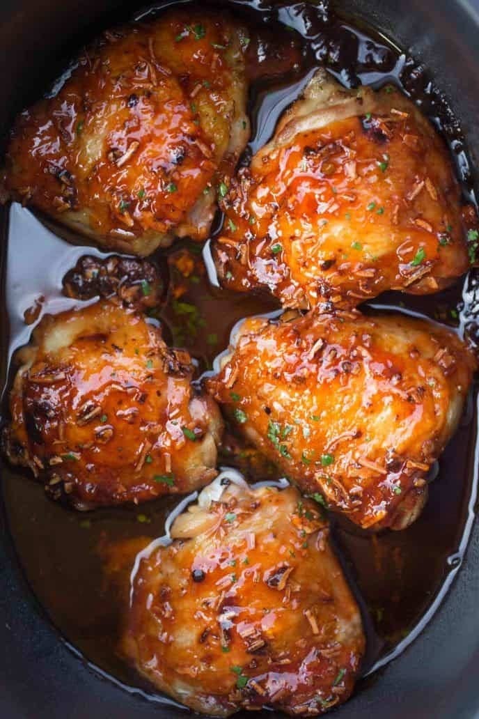 Apricot glazed chicken thighs in a slow cooker.
