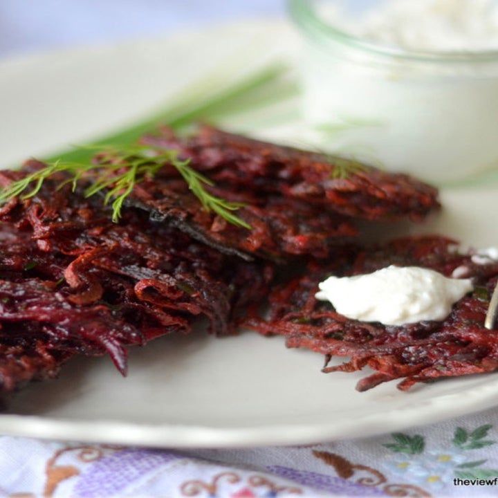 A plate of red beet latkes topped with dill and crème fraîche.