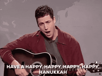 Adam Sandler singing &quot;Eight Crazy Nights&quot; while strumming a guitar. 