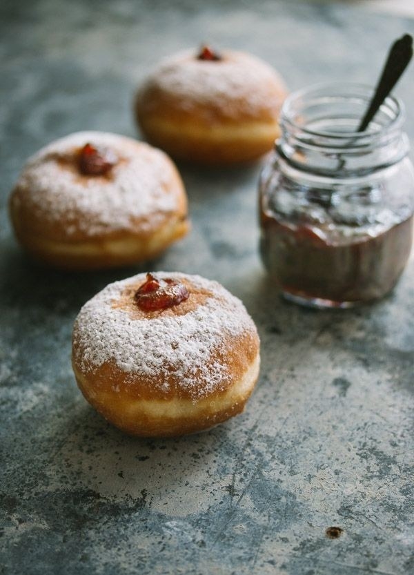 Three jelly-filled donuts topped with powdered sugar.