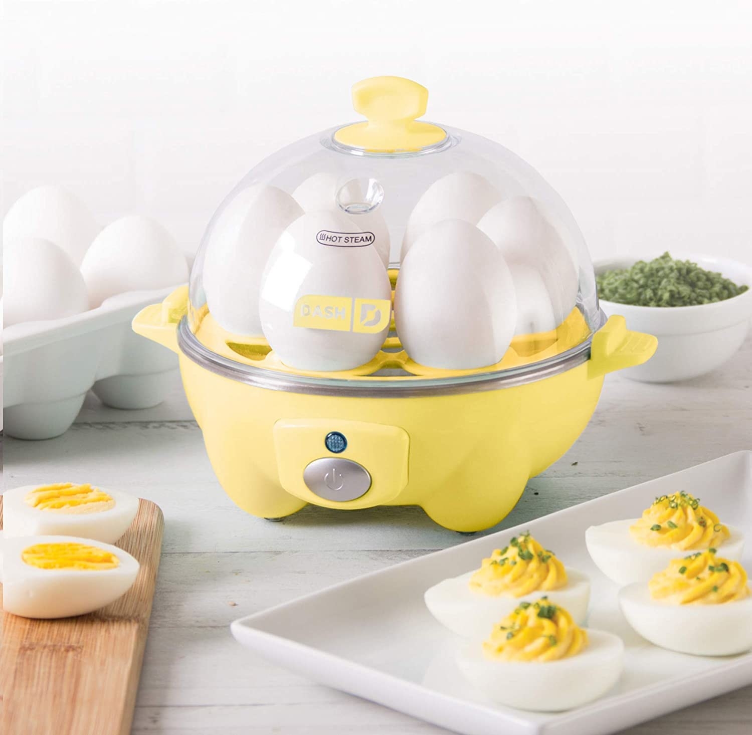 The egg cooker next to a plate of deviled eggs