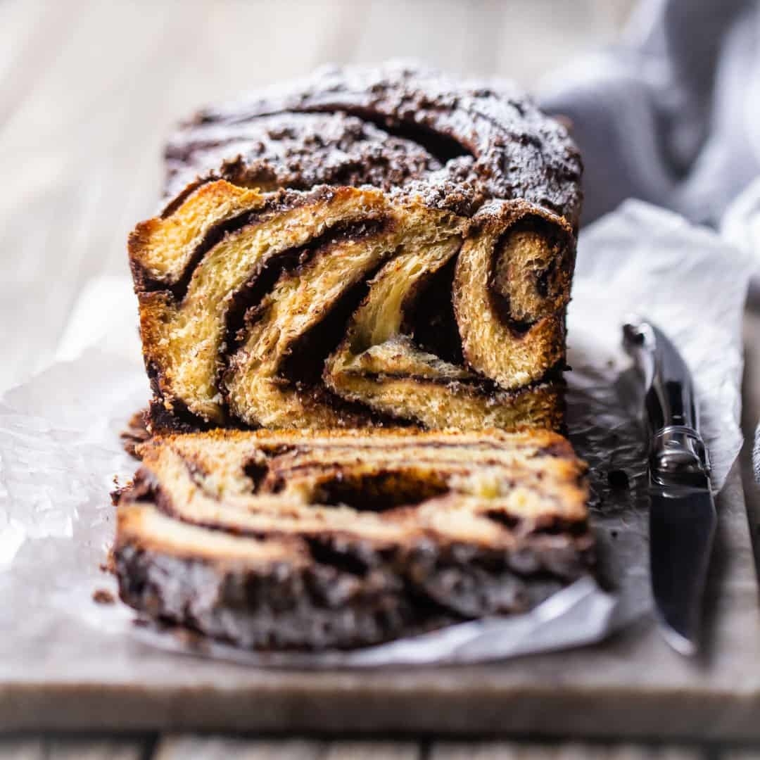 A chocolate babka sliced to reveal a moist brioche loaf with chocolate swirls.