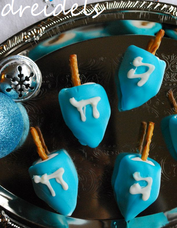 Several chocolate covered marshmallow dreidels with pretzels.