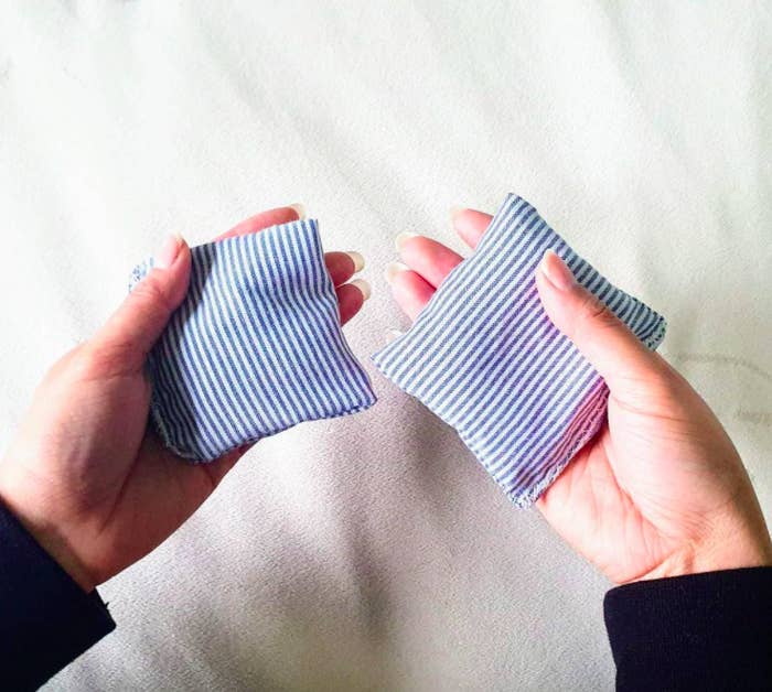 A person holding a hand warmer in each palm