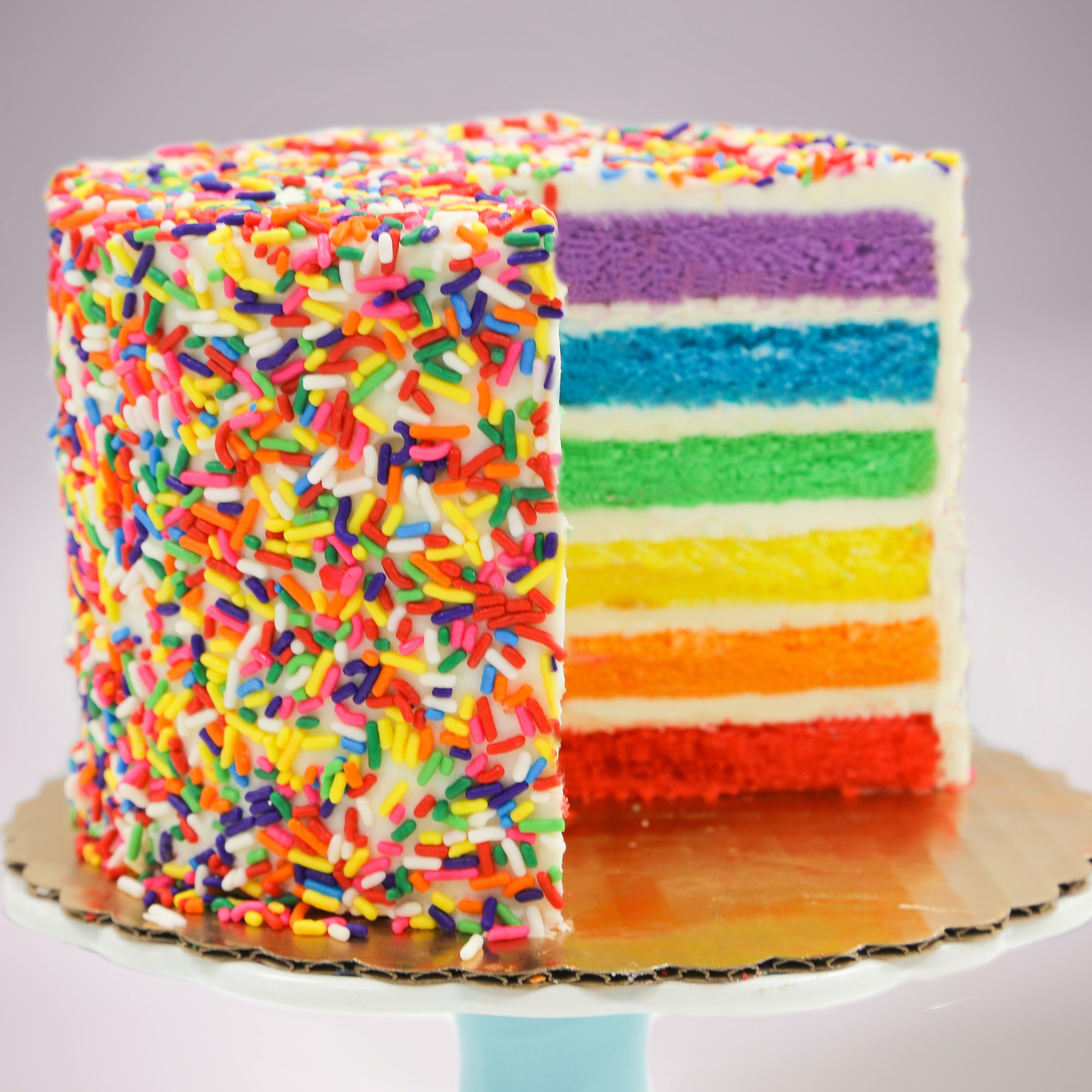 A rainbow-sprinkled cake layered with different rainbow colors